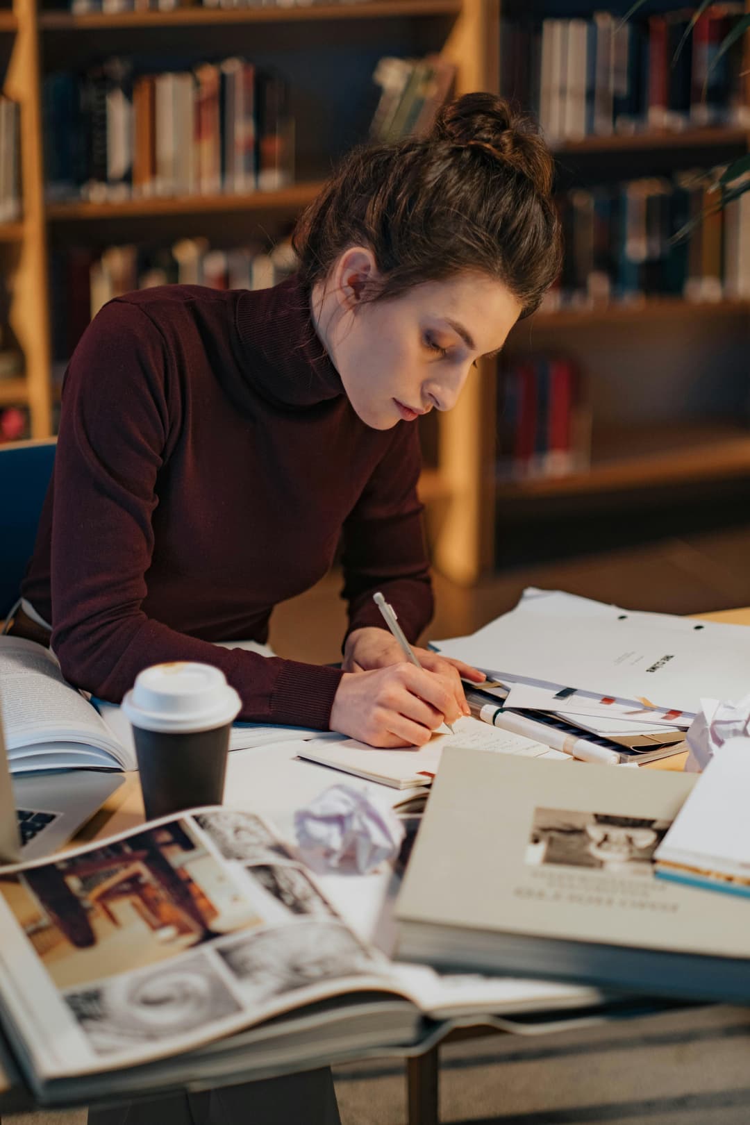 Writer at a bright desk with notebook and laptop